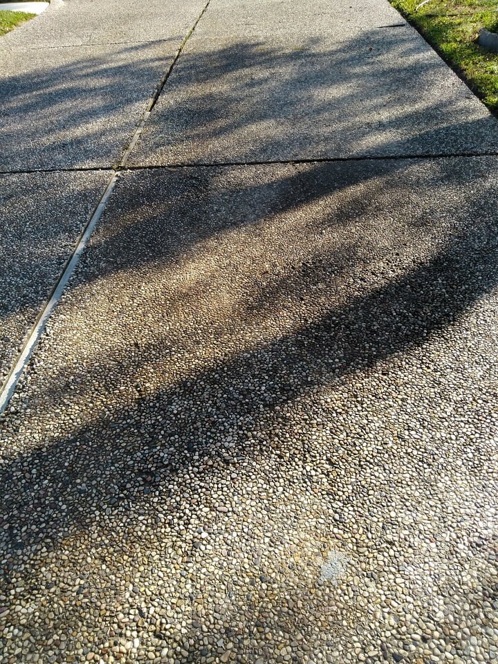 Severe oil stain in pea rock driveway by LKJ Preferred Services, Houston TX