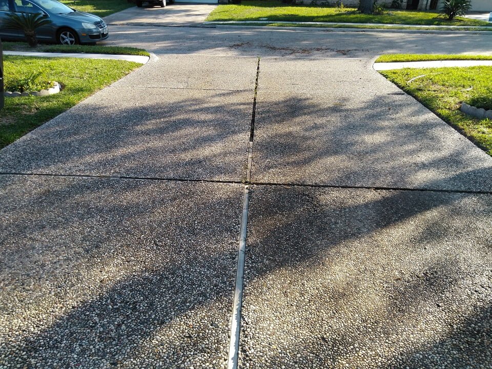 Severe oil stain in pea rock driveway, second angle, by LKJ Preferred Services, Houston TX